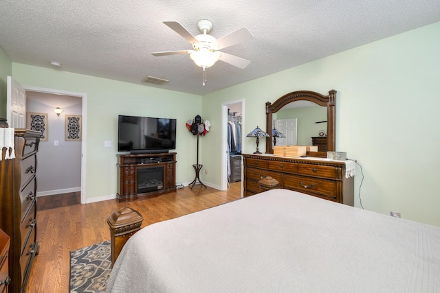 256 Ridge Lake Dr, Manning, SC 29102 - bedroom with a spacious closet, wood finished floors, a ceiling fan, a closet, and a textured ceiling