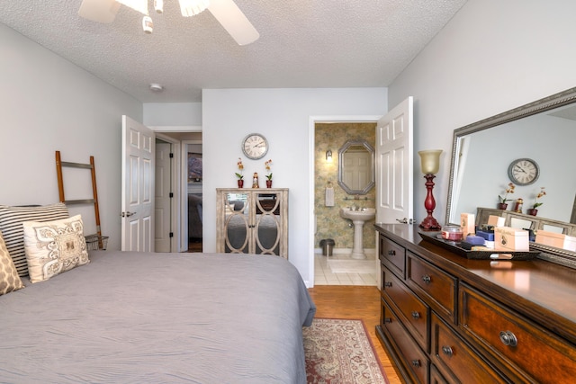 256 Ridge Lake Dr, Manning, SC 29102 - bedroom with a textured ceiling, ensuite bath, ceiling fan, and light wood-style flooring