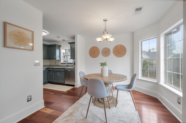 dining room featuring dark hardwood / wood-style flooring, a notable chandelier, and sink