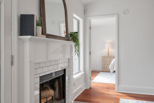 interior space with hardwood / wood-style flooring and a brick fireplace