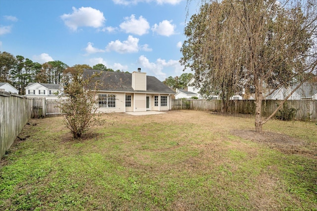 rear view of house featuring a lawn and a patio area