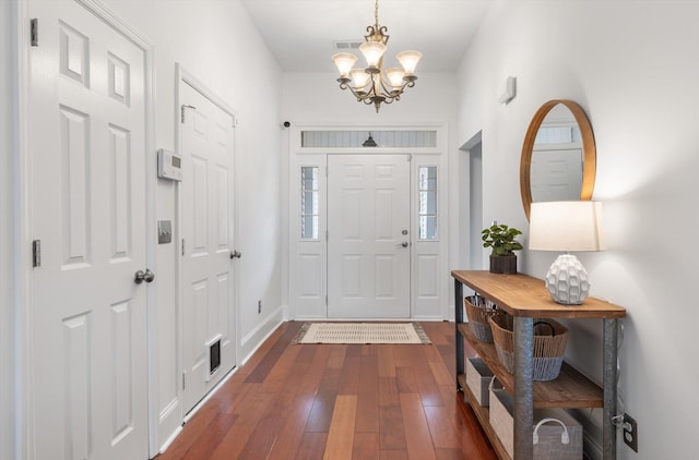 foyer with dark hardwood / wood-style floors and an inviting chandelier