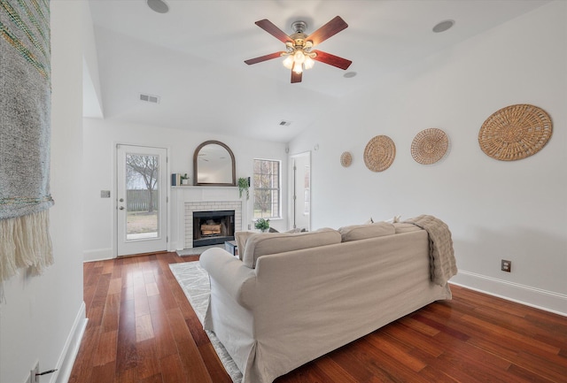 living room with ceiling fan, dark hardwood / wood-style flooring, lofted ceiling, and a fireplace