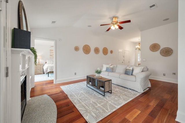 living room featuring ceiling fan with notable chandelier, wood-type flooring, and lofted ceiling