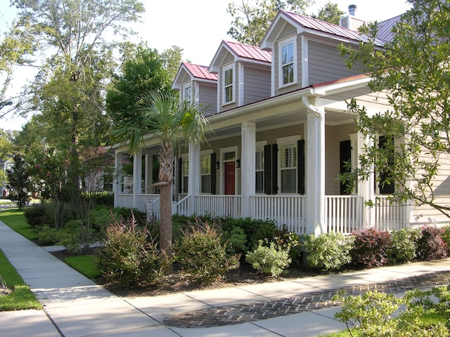 7021 Schooner St, Charleston, SC 29492 - view of front of property with a porch, a chimney, a metal roof, and a standing seam roof