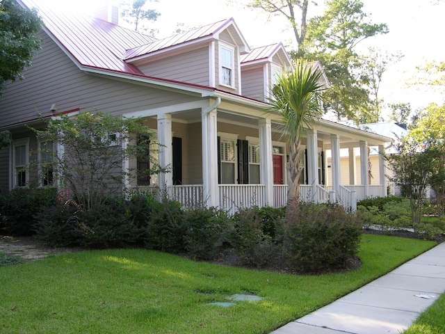 7021 Schooner St, Charleston, SC 29492 - view of front of home with a porch, a front yard, and a metal roof