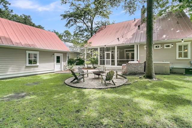 7021 Schooner St, Charleston, SC 29492 - back of property with a metal roof, a fire pit, a yard, a sunroom, and a chimney