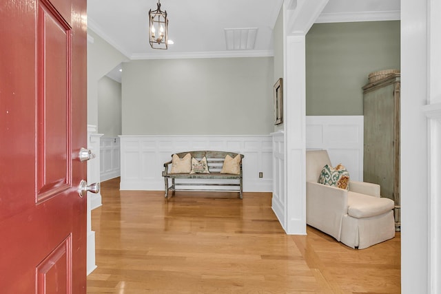 7021 Schooner St, Charleston, SC 29492 - entrance foyer featuring a wainscoted wall, crown molding, light wood-style floors, and a chandelier