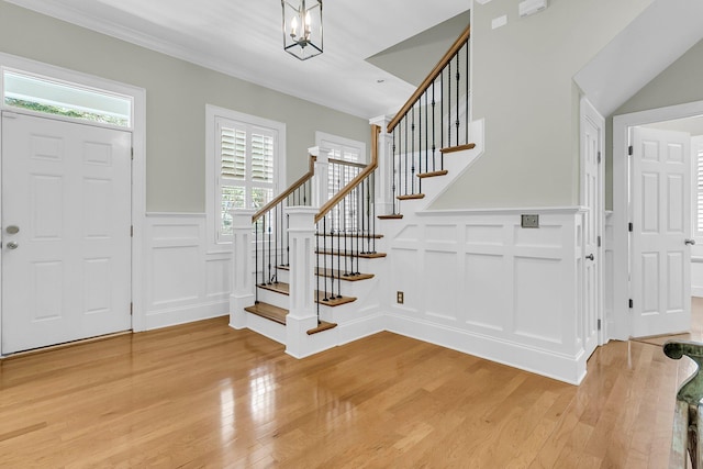 7021 Schooner St, Charleston, SC 29492 - foyer featuring a decorative wall, stairway, light wood finished floors, a wainscoted wall, and crown molding