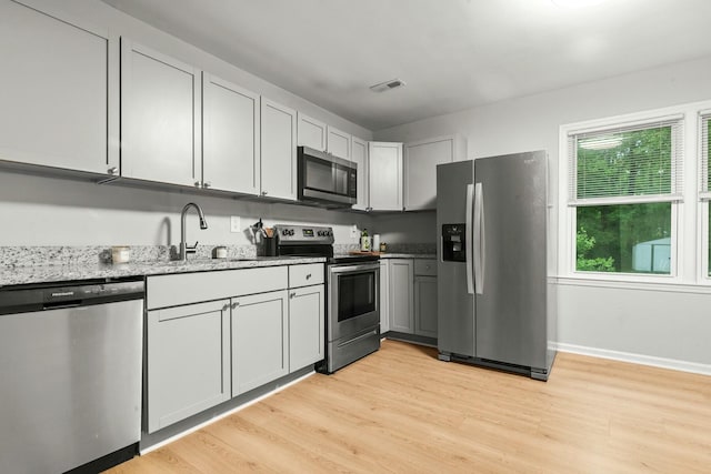 120 Lisa Dr, Summerville, SC 29485 - kitchen featuring stainless steel appliances, visible vents, a sink, light stone countertops, and light wood-style flooring