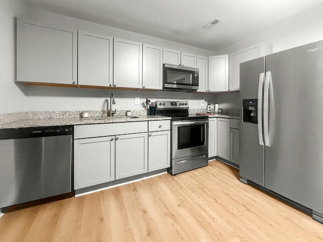 120 Lisa Dr, Summerville, SC 29485 - kitchen featuring light stone countertops, stainless steel appliances, light wood finished floors, and a sink