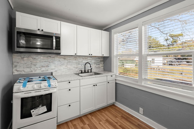 3113 Matipan Ave, North Charleston, SC 29405 - kitchen with stainless steel microwave, gas range gas stove, light wood-type flooring, and white cabinetry