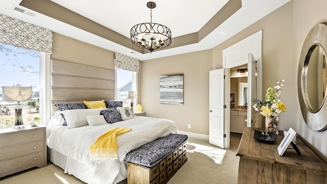 carpeted bedroom featuring a notable chandelier and a tray ceiling