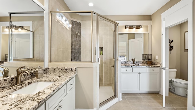 bathroom featuring vanity, tile patterned floors, a shower with door, and toilet