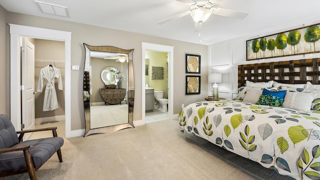 carpeted bedroom featuring ensuite bath, ceiling fan, and a closet