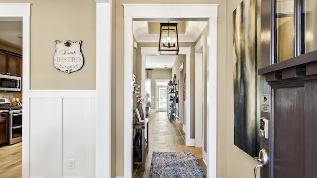 hallway featuring light wood-type flooring and ornamental molding