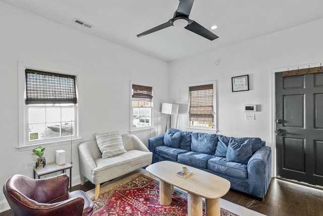 living room with dark hardwood / wood-style flooring and ceiling fan