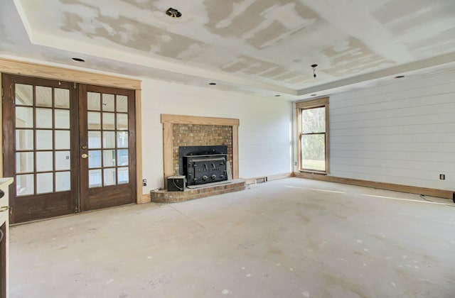 unfurnished living room with a wood stove and french doors