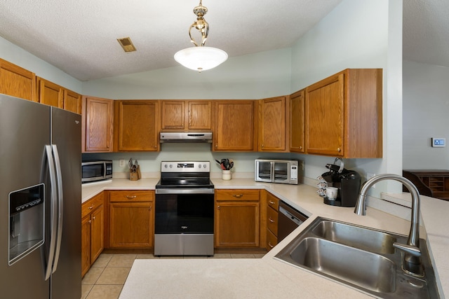 3347 Walter Dr, Johns Island, SC 29455 - kitchen with appliances with stainless steel finishes, under cabinet range hood, vaulted ceiling, light tile patterned flooring, and brown cabinets