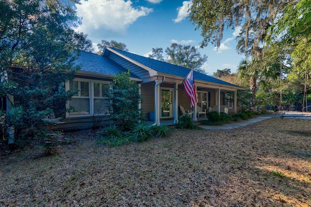 view of front of property featuring covered porch and roof with shingles