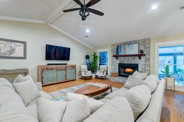 living room with visible vents, a fireplace, lofted ceiling with beams, and wood finished floors