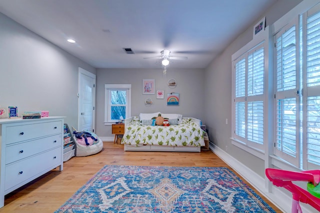 bedroom with baseboards, ceiling fan, visible vents, and light wood-style floors