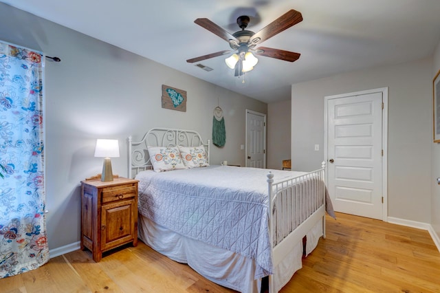 bedroom featuring visible vents, light wood-style flooring, and baseboards