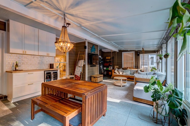 dining area with wine cooler and a notable chandelier