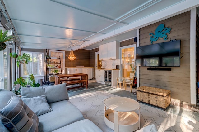 living room with beverage cooler and wooden walls