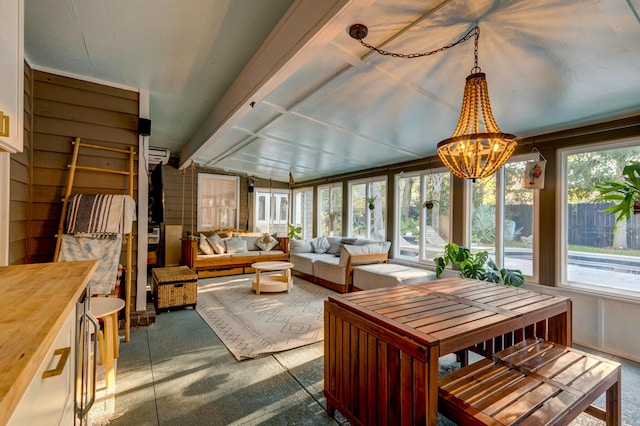 sunroom with lofted ceiling with beams, an inviting chandelier, and plenty of natural light