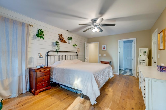 bedroom featuring light wood finished floors, baseboards, visible vents, and a ceiling fan