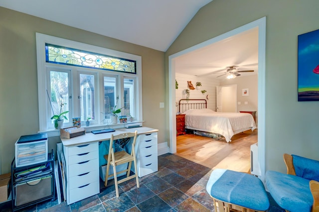 bedroom with lofted ceiling, baseboards, and stone tile flooring