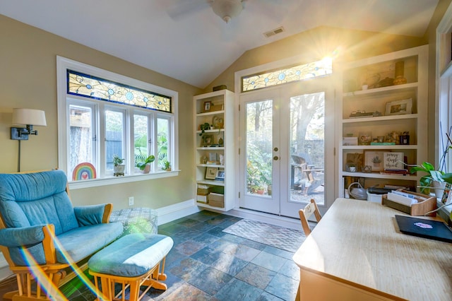 interior space featuring built in shelves, french doors, lofted ceiling, stone finish flooring, and baseboards