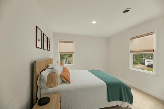 carpeted bedroom featuring multiple windows