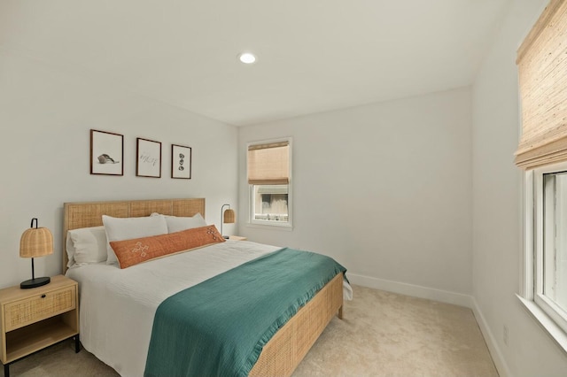 bedroom featuring light colored carpet and multiple windows