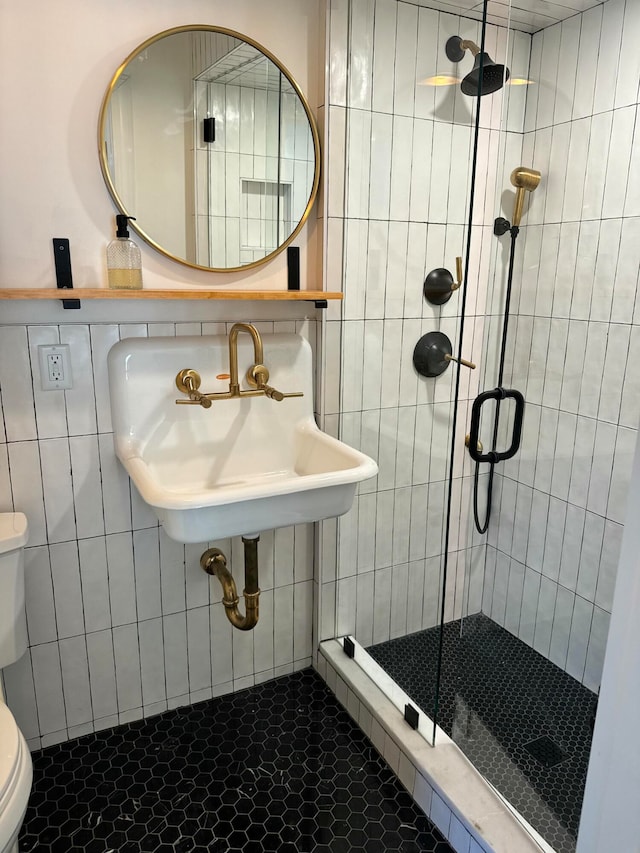 bathroom featuring sink, walk in shower, tile patterned floors, toilet, and tile walls