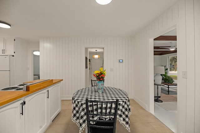 dining space with wood walls and light tile patterned floors