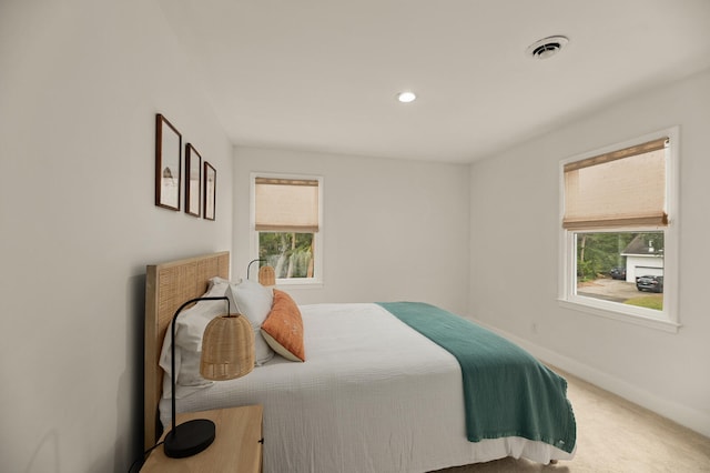 bedroom with multiple windows and carpet