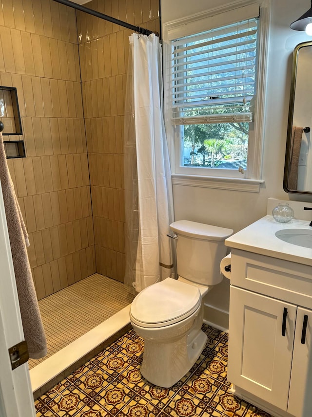 bathroom featuring tile patterned floors, vanity, toilet, and curtained shower