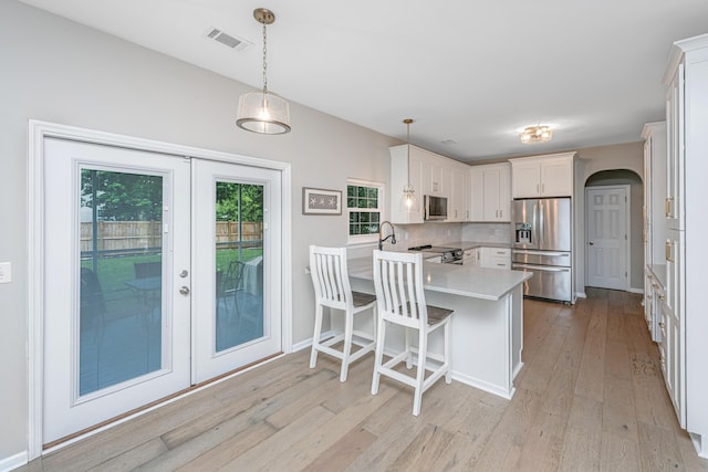 468 Maple Oak Ln, Charleston, SC 29414 - kitchen with stainless steel appliances, a peninsula, light countertops, light wood finished floors, and french doors