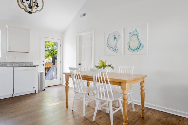 dining room with baseboards, visible vents, wood finished floors, high vaulted ceiling, and a notable chandelier