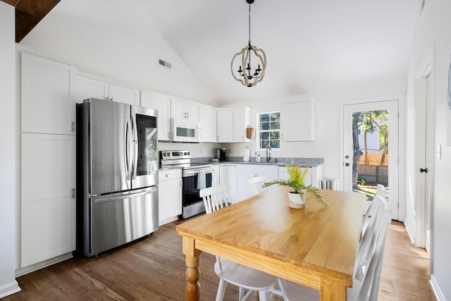 kitchen with white cabinetry, stainless steel appliances, a sink, and wood finished floors