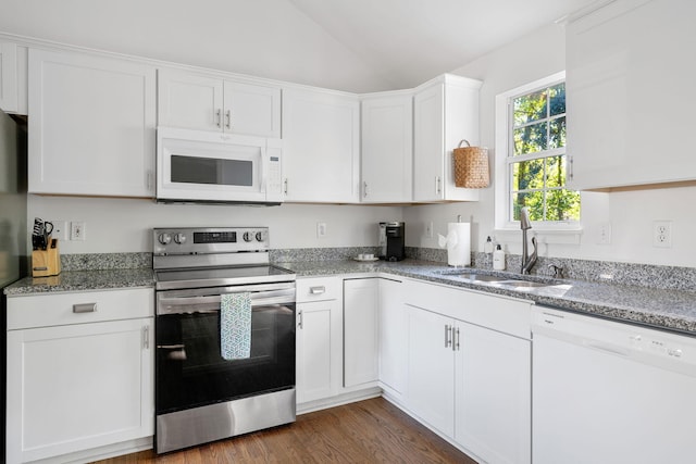 kitchen featuring light stone counters, white cabinets, vaulted ceiling, a sink, and white appliances