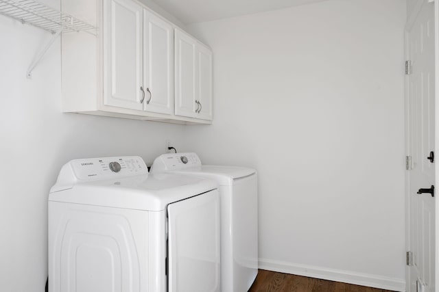 washroom featuring cabinet space, dark wood-style floors, baseboards, and washing machine and clothes dryer