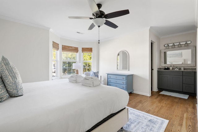 bedroom with baseboards, visible vents, ornamental molding, light wood-style floors, and a sink