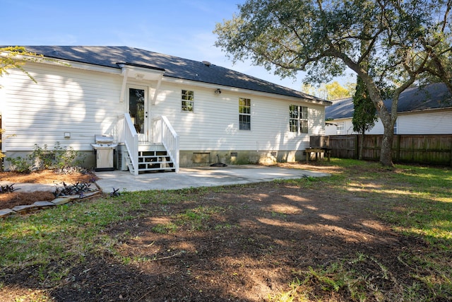 rear view of house featuring crawl space, a patio area, and fence