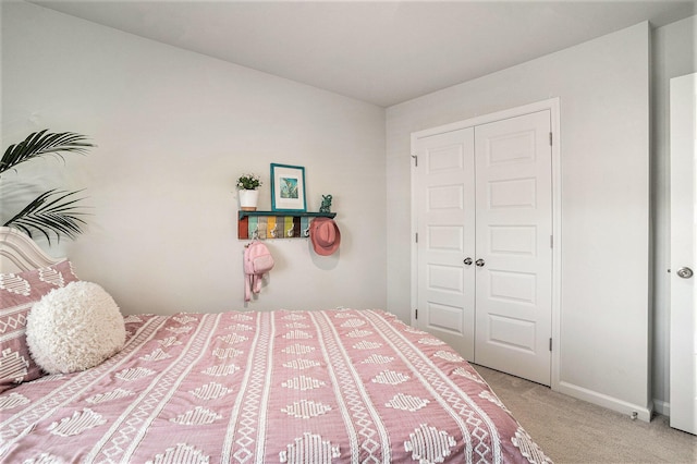 bedroom featuring baseboards, a closet, and light carpet