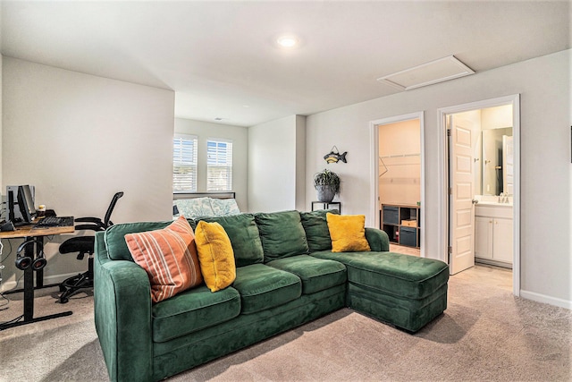 living room with attic access, carpet, and baseboards