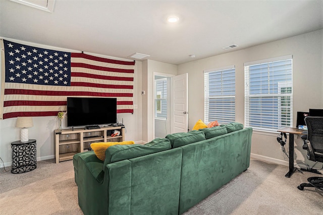 living area featuring visible vents, a healthy amount of sunlight, baseboards, and carpet floors