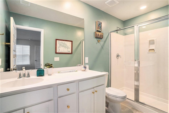 bathroom with vanity, toilet, visible vents, and a stall shower